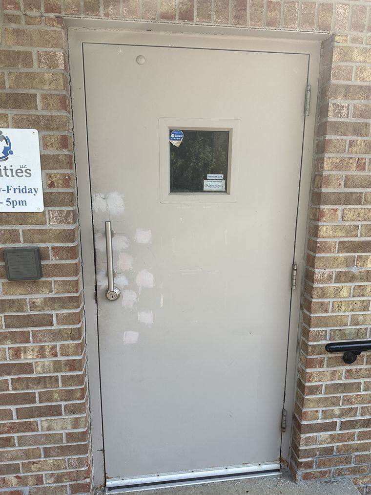 Commercial steel door with worn paint and old hardware
